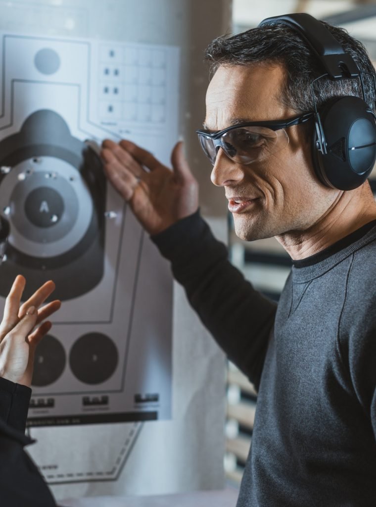 shooting-instructor-showing-on-used-target-with-holes.jpg